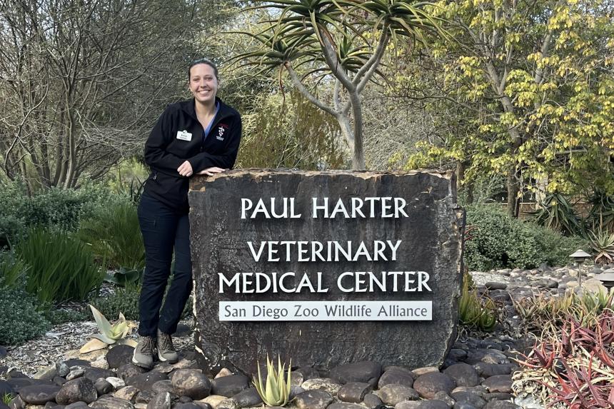 Erica Jackson with a sign that reads Paul Harter Veterinary Medical Center San Diego Zoo Wildlife Alliance
